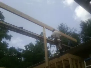 Carpenter setting a ridge beam over a new addition frame — Ice Dam Removal by Roofing Brothers in Broomall