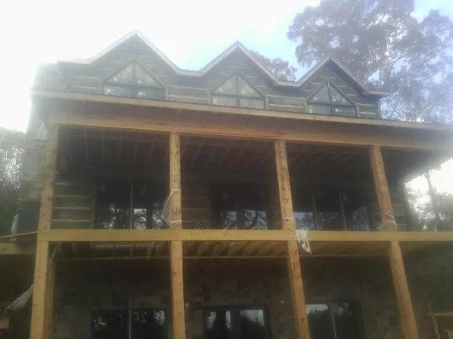 Dormers and porch framing on a large log home under construction — Roof Coating work by our crew in Broomall