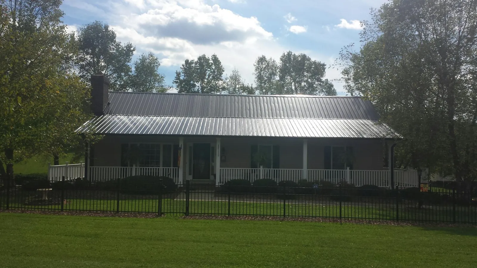 Gray metal roof on a brick ranch with a full width front porch — Gutter Guard Installation work by our crew in Broomall